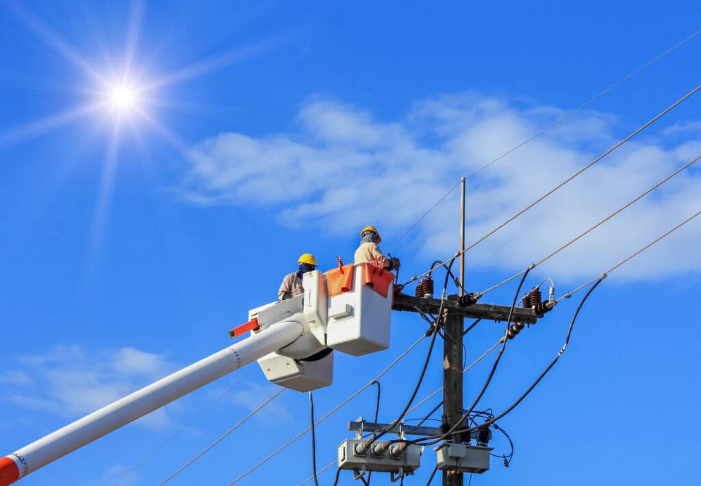 Workers in a cherry picker working on a utility line